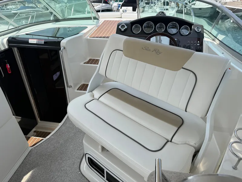 Slide: The Image of The image shows the cockpit of a 2010 Sea Ray Sundancer 310 with white upholstery. - 17