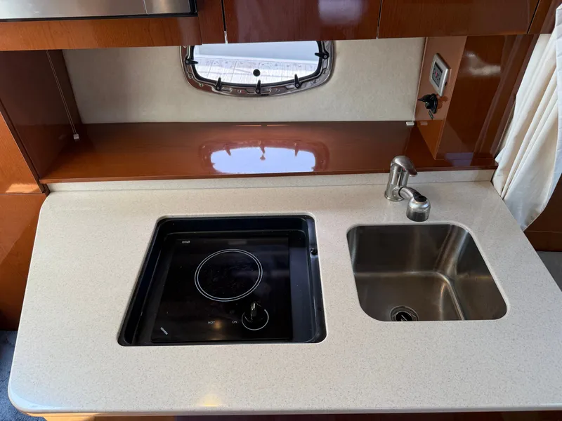 Slide: The Image of The galley of the 2010 Sea Ray Sundancer 310 features a cooktop and a sink. - 30