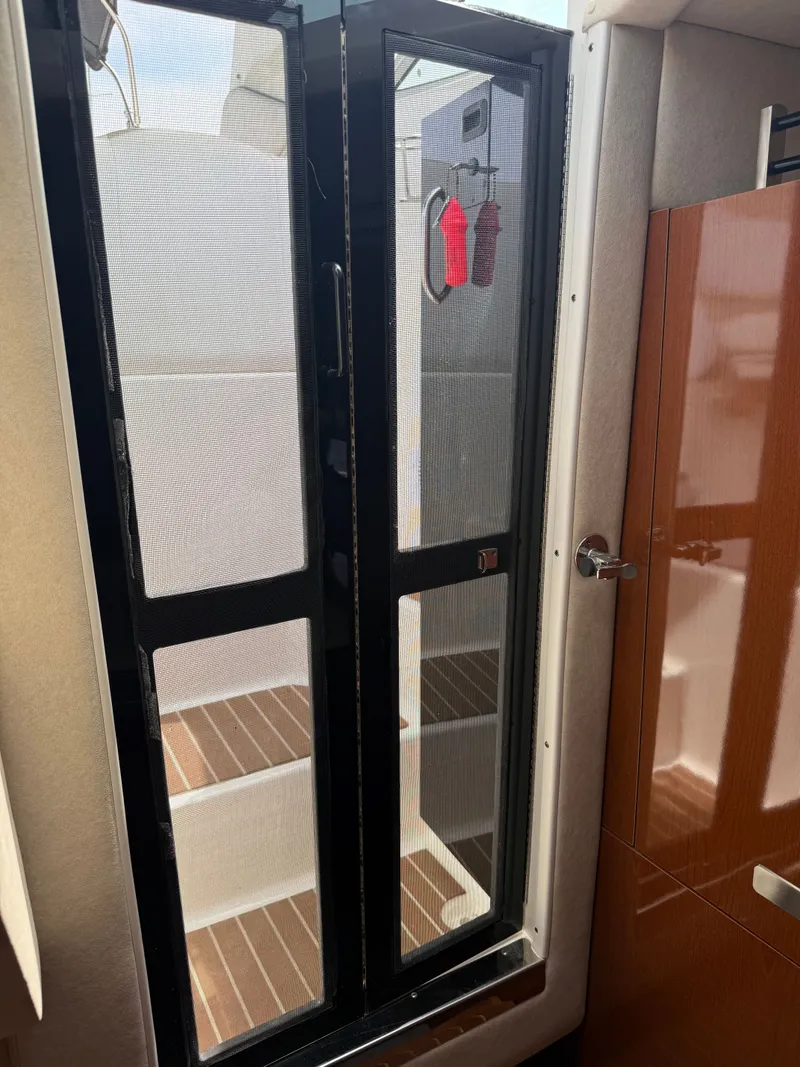 Slide: The Image of The cabin of a 2010 Sea Ray Sundancer 310 features a glass door leading to the deck. - 42