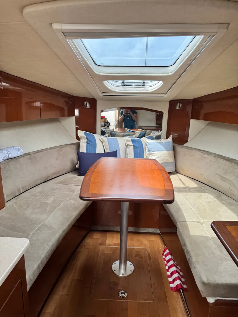Slide: The Image of Interior of a Sea Ray Sundancer 310 with cozy seating and a wooden table. - 24