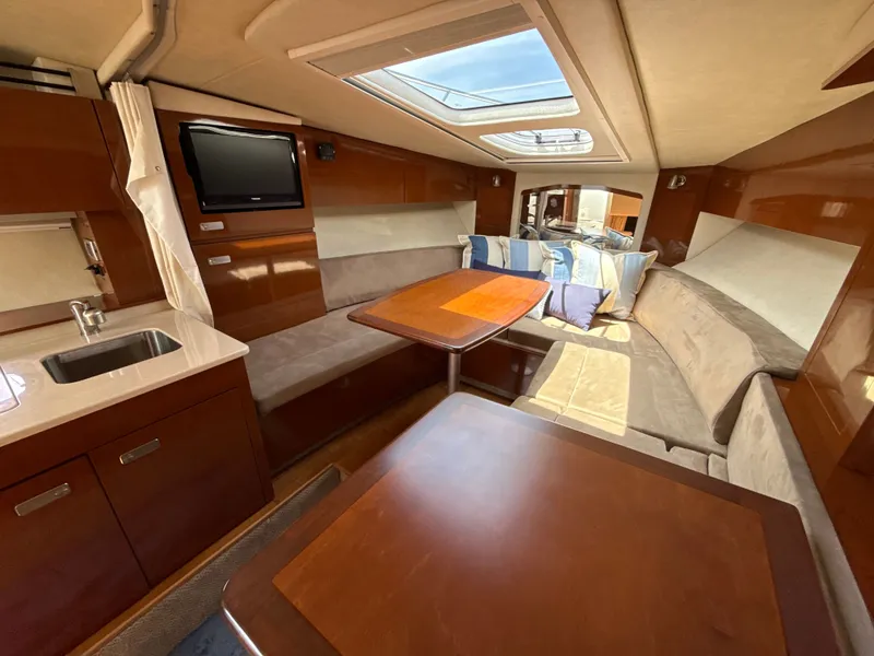 Slide: The Image of Interior of a 2010 Sea Ray Sundancer 310 with cozy seating area and wooden table. - 28