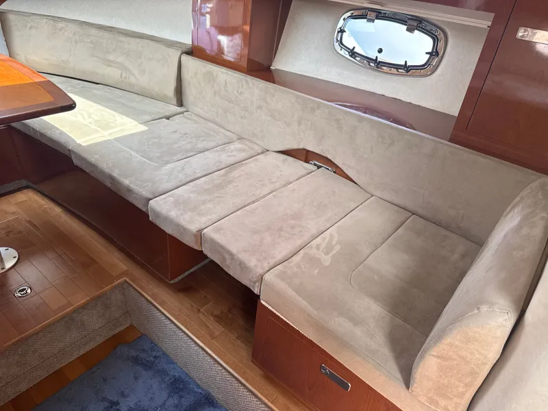Slide: The Image of Interior of a 2010 Sea Ray Sundancer 310 with beige sofa and wooden flooring. - 35