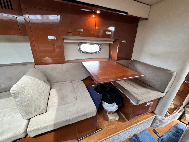 Slide: The Image of Interior of a Sea Ray Sundancer 310 with a cozy seating area and wooden table. - 27