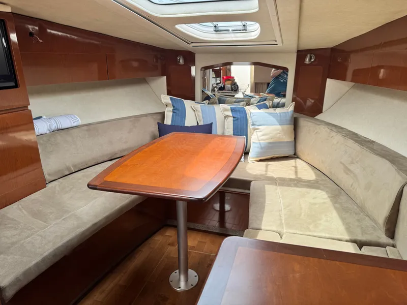 Slide: The Image of Interior of a Sea Ray Sundancer 310 with cozy seating and a wooden table. - 23
