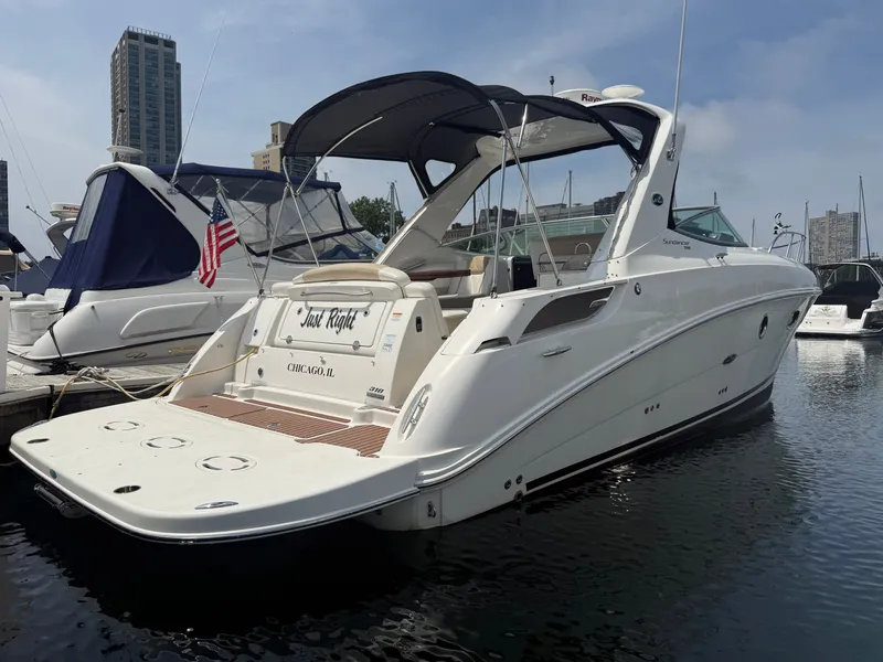 Slide: The Image of A 2010 Sea Ray Sundancer 310 docked in a marina. It features a sleek, white design. - 3