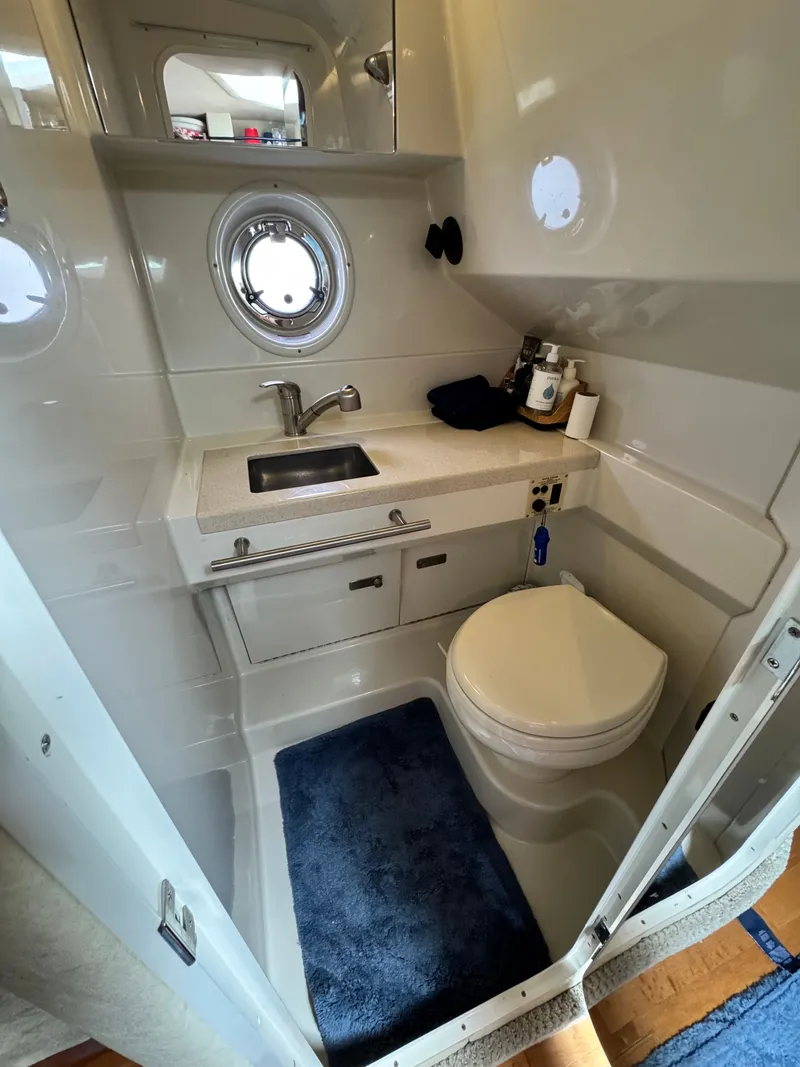 Slide: The Image of The image shows a boat bathroom with a sink, toilet, and porthole. - 28