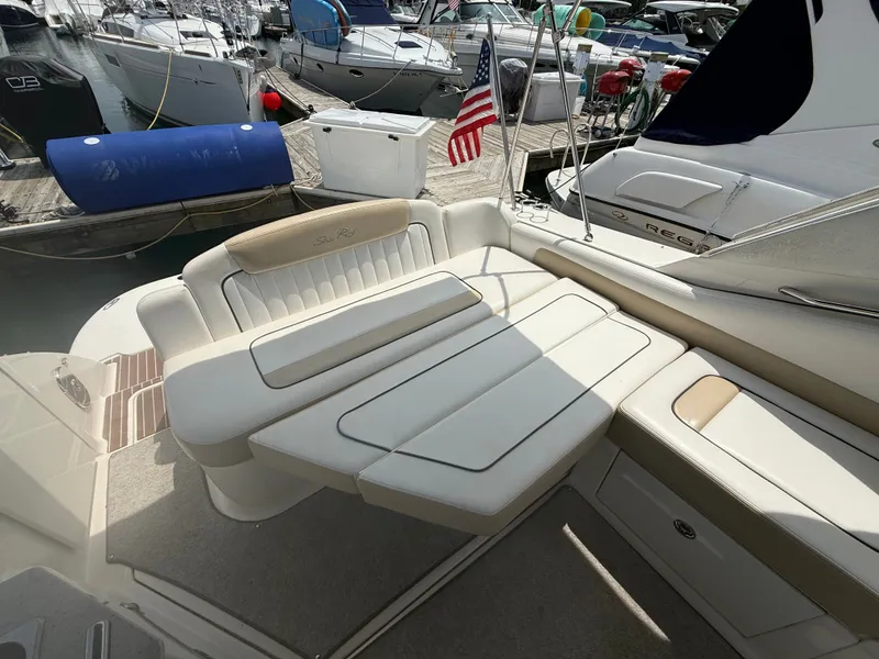 Slide: The Image of The image shows the cockpit of a Sea Ray Sundancer 310 with beige cushioned seating and an American flag. - 19
