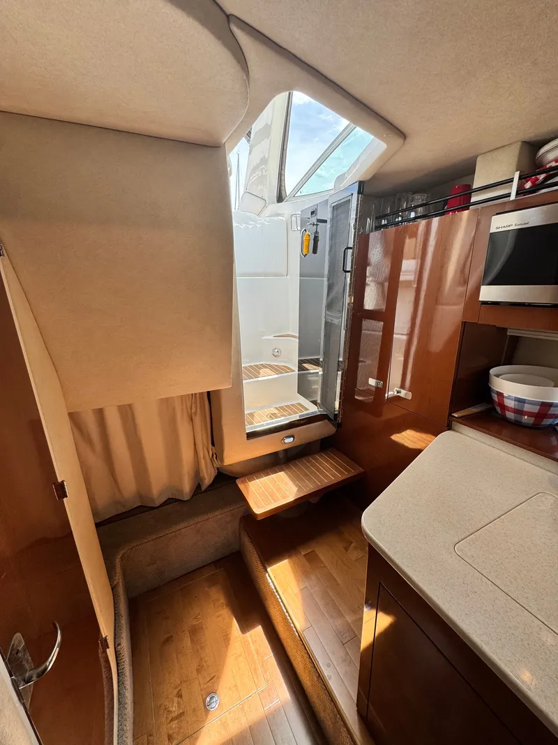 Slide: The Image of Interior of the 2010 Sea Ray Sundancer 310 with wooden flooring and modern amenities. - 22