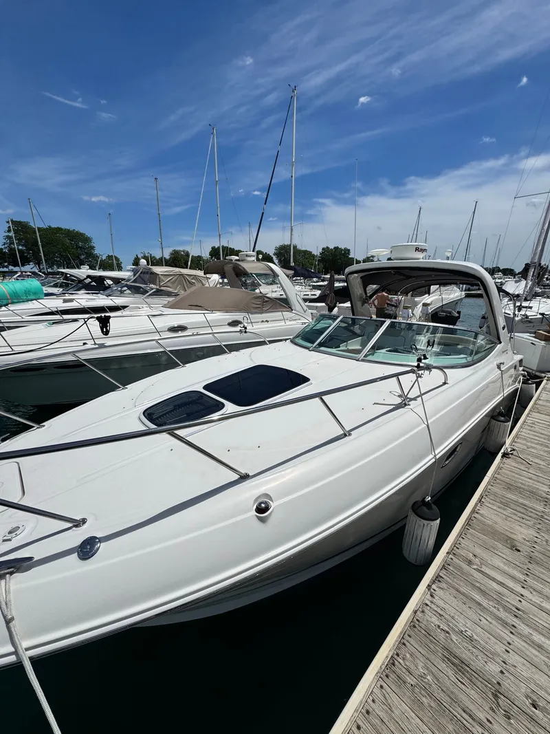 Slide: The Image of A white 2010 Sea Ray Sundancer 310 boat docked, with other boats visible in the background. - 3