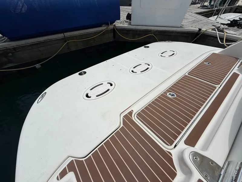 Slide: The Image of The swim platform of a 2010 Sea Ray Sundancer 310 with wood-like finish and access hatches. - 46
