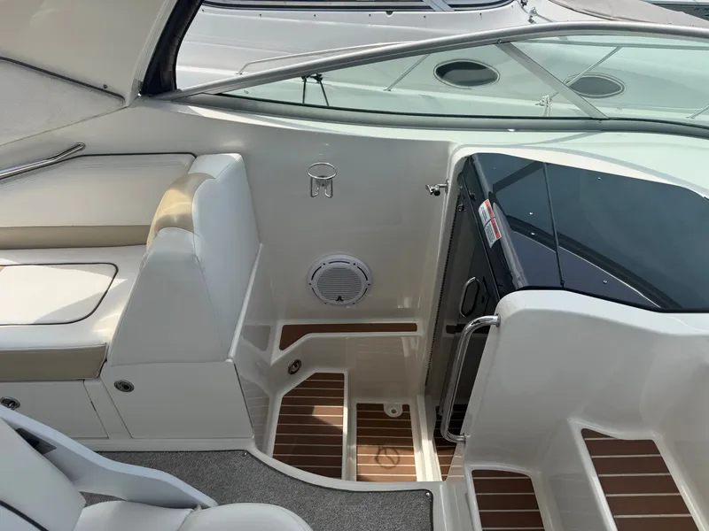 Slide: The Image of The image shows the cockpit of a 2010 Sea Ray Sundancer 310 with white seating and wood flooring. - 23
