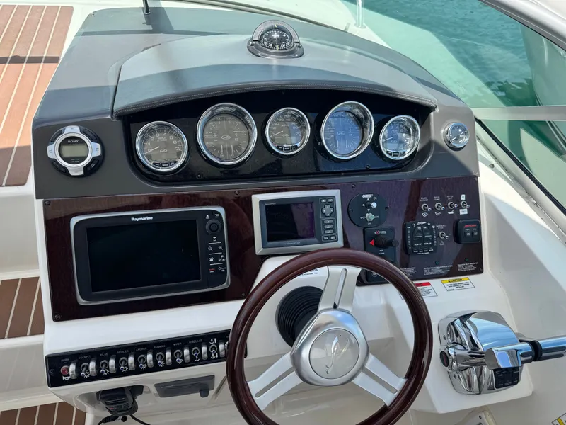 Slide: The Image of The dashboard of a 2010 Sea Ray Sundancer 310 with multiple gauges and a wooden steering wheel. - 15