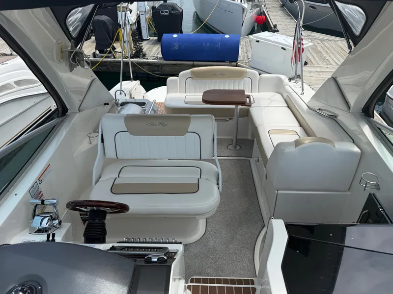 Slide: The Image of The image shows the cockpit of a 2010 Sea Ray Sundancer 310 with elegant seating and tables. - 8
