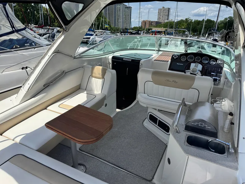 Slide: The Image of The image shows the cockpit of a Sea Ray Sundancer 310 with beige seating and a wooden table. - 10