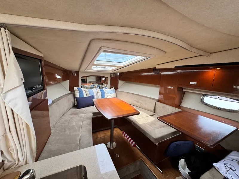 Slide: The Image of Interior of a Sea Ray Sundancer 310 with cozy seating area and wooden table. - 25