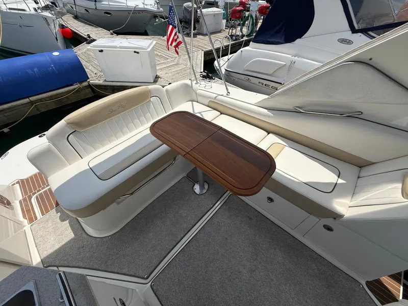 Slide: The Image of The image shows the seating area of a 2010 Sea Ray Sundancer 310 with a wooden table. - 15