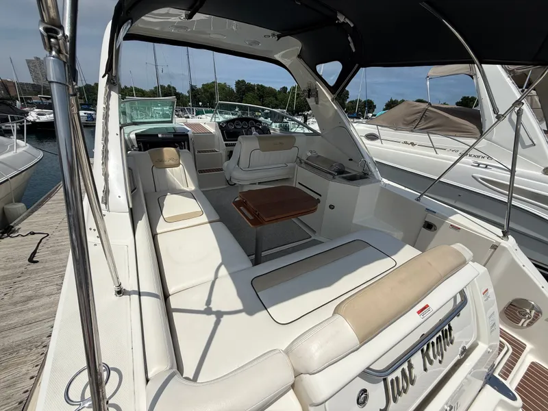 Slide: The Image of The image shows the cockpit of a 2010 Sea Ray Sundancer 310 with beige seating and a wooden table. - 13