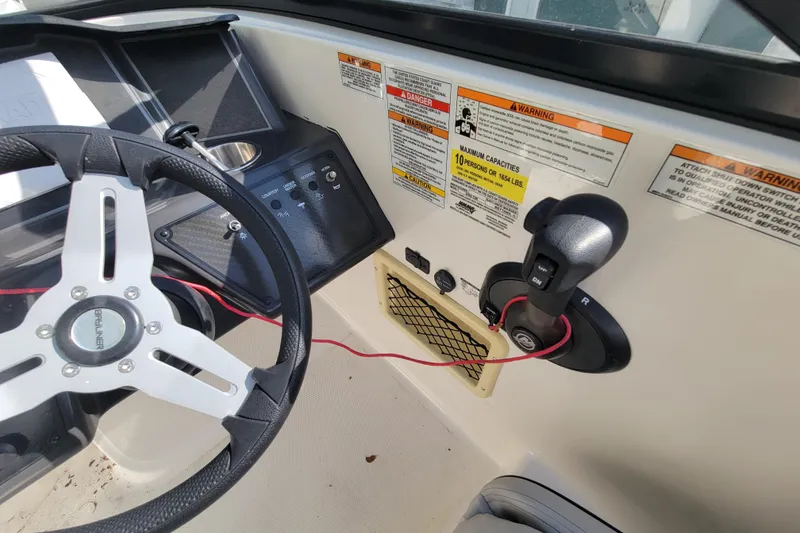 Slide: The Image of 2023 Bayliner VR6 Bowrider OB dashboard with steering wheel and control panel. - 18