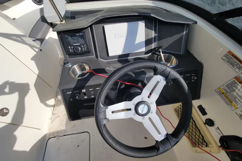 Slide: The Image of 2023 Bayliner VR6 Bowrider OB dashboard with steering wheel and control panel. - 19
