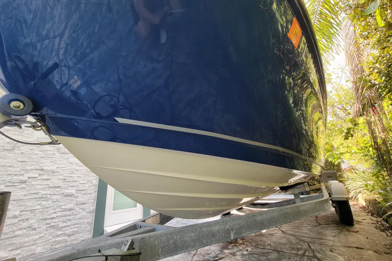 Slide: The Image of 2023 Bayliner VR6 Bowrider OB on trailer, blue hull, parked outdoors. - 5