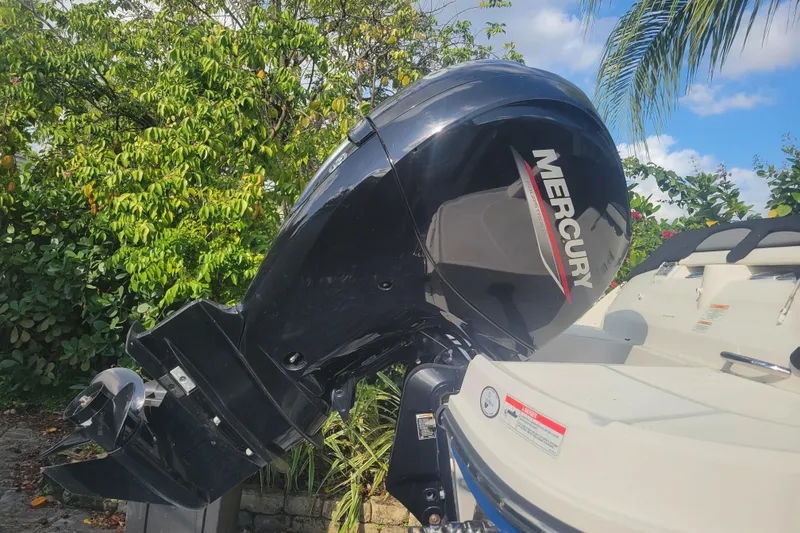 Slide: The Image of 2023 Bayliner VR6 Bowrider OB with Mercury outboard motor, surrounded by lush greenery. - 6