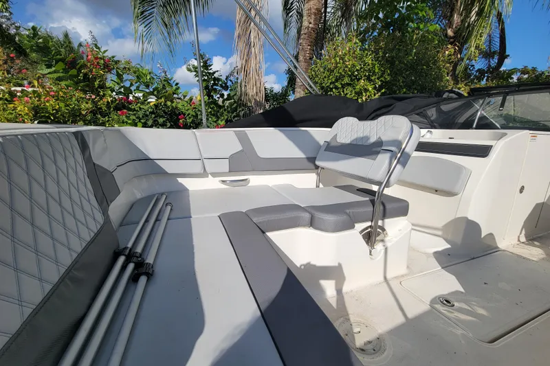 Slide: The Image of 2023 Bayliner VR6 Bowrider OB interior with gray seating, surrounded by lush greenery. - 15