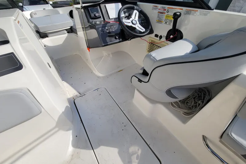 Slide: The Image of 2023 Bayliner VR6 Bowrider OB interior with steering wheel and seating area. - 13