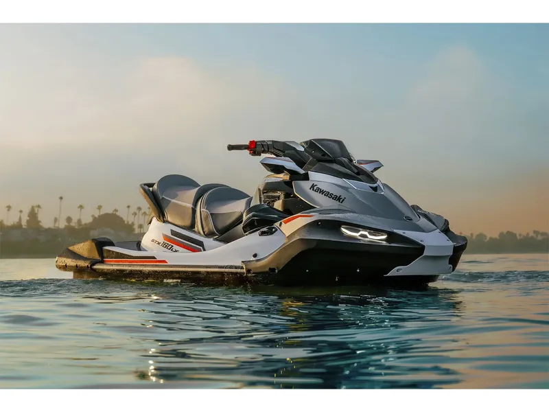 Slide: The Image of A 2026 Kawasaki Jet Ski® STX® 160LX on calm water at sunset. - 17