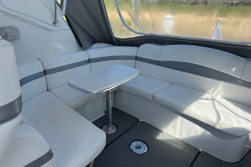 Slide: The Image of Interior of a 2004 Formula 37 Performance Cruiser with white seating and a small table. - 6