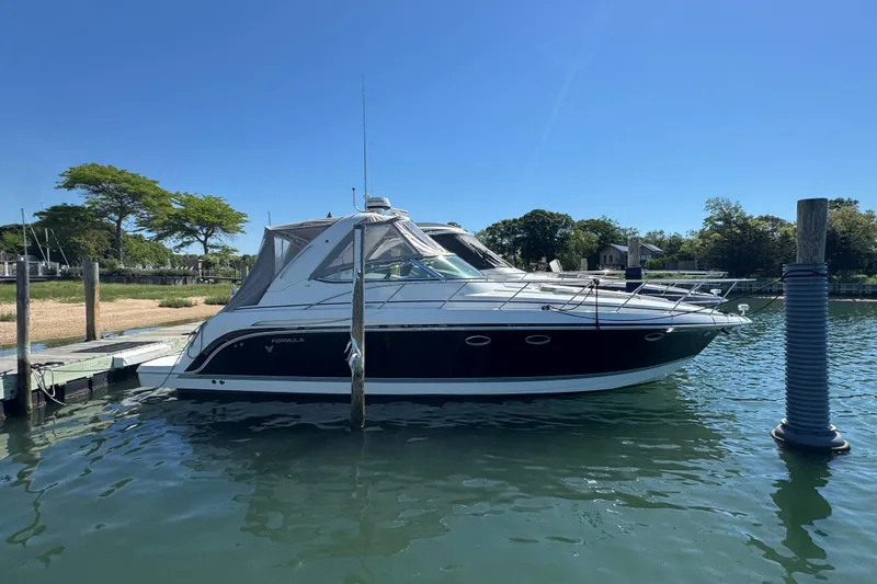 Slide: The Image of 2004 Formula 37 Performance Cruiser docked in a serene marina setting. - 1