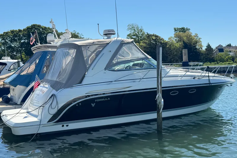Slide: The Image of 2004 Formula 37 Performance Cruiser docked in a serene marina setting. - 2