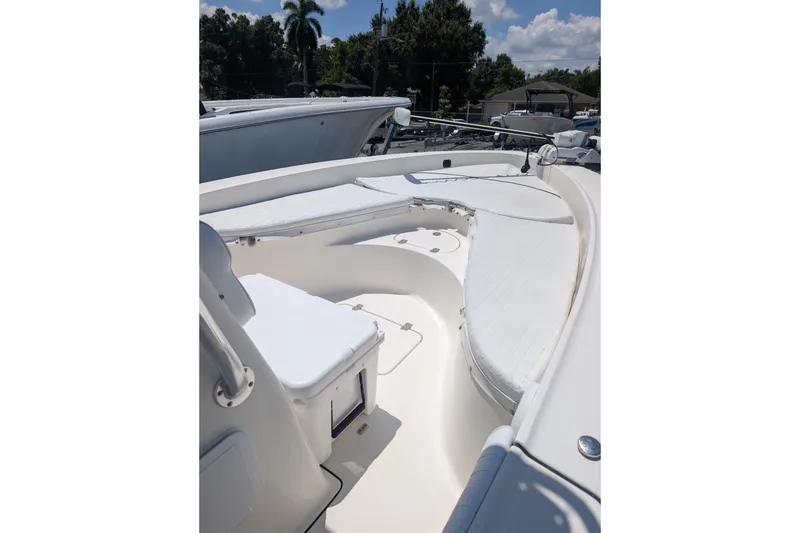 Slide: The Image of 2009 Pioneer 220 Bay Sport boat interior with seating and storage, under a clear blue sky. - 3