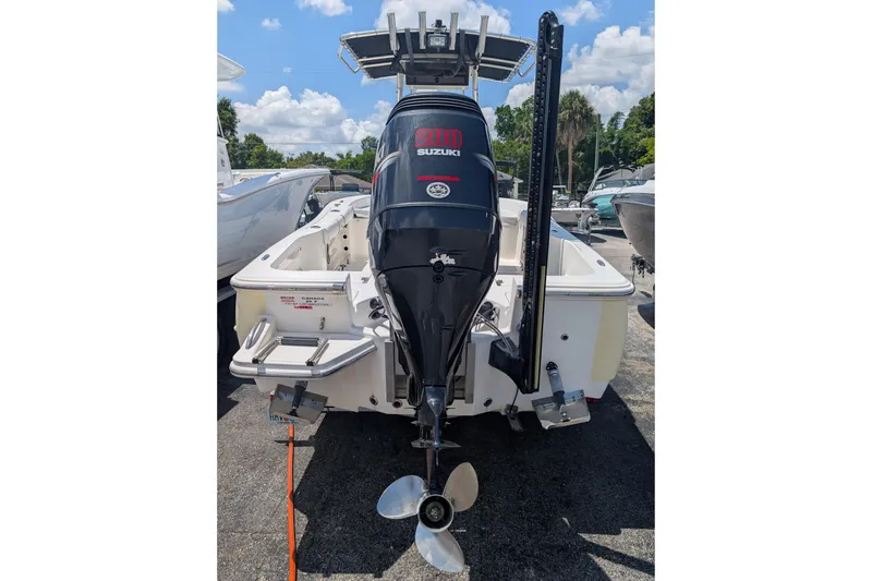 Slide: The Image of 2009 Pioneer 220 Bay Sport boat with Suzuki outboard motor, docked under a sunny sky. - 2