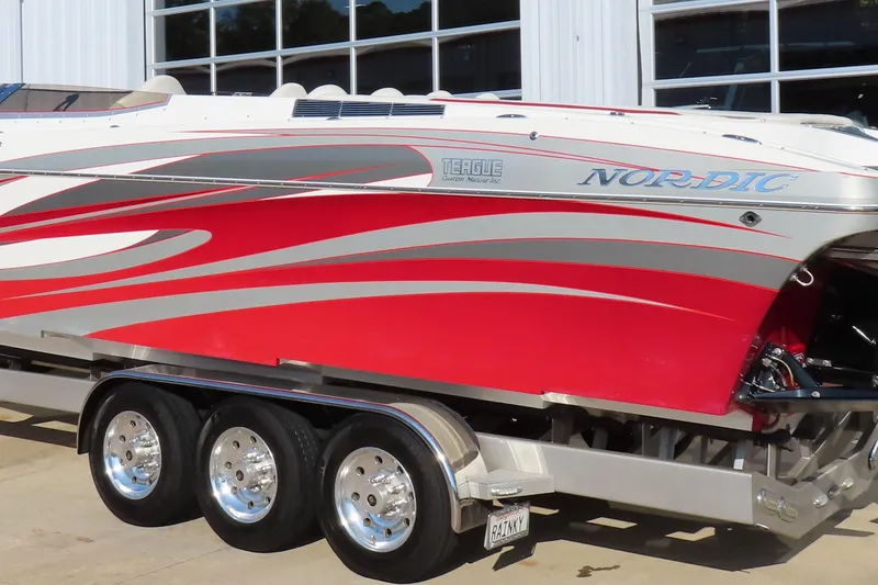Slide: The Image of 2013 Nordic 39 POKER RUN boat with red and silver design on a trailer. - 9