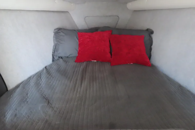 Slide: The Image of Cozy cabin bed in 2013 Nordic 39 Poker Run boat with red pillows and gray bedding. - 31