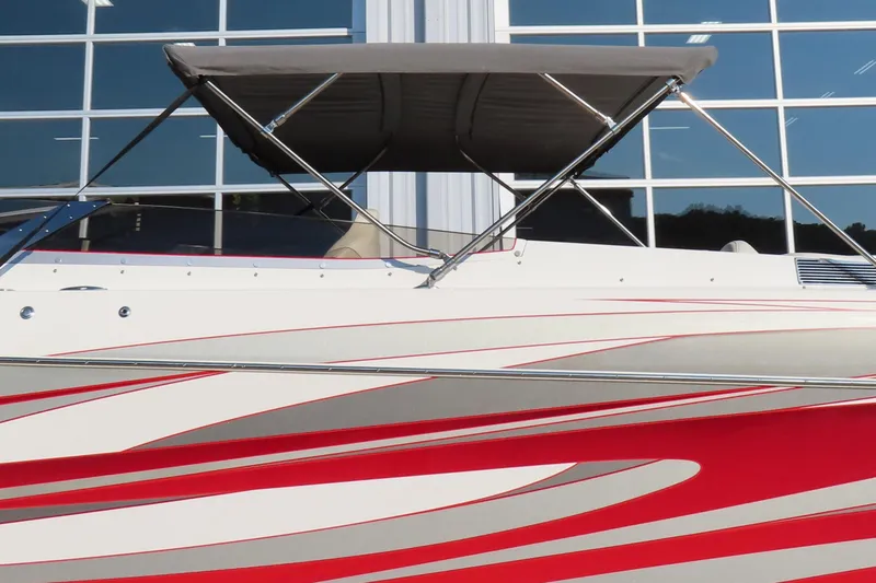 Slide: The Image of 2013 Nordic 39 POKER RUN boat with red and white design, parked near glass windows. - 3