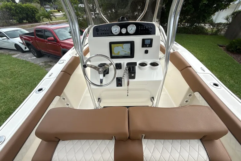 Slide: The Image of 2023 Pioneer 202 Islander boat cockpit with steering wheel, navigation system, and brown seating. - 4