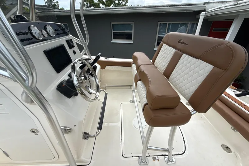 Slide: The Image of 2023 Pioneer 202 Islander boat interior with steering wheel and cushioned seating. - 6