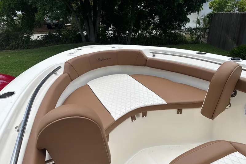 Slide: The Image of 2023 Pioneer 202 Islander boat interior with tan and white cushioned seating. - 12