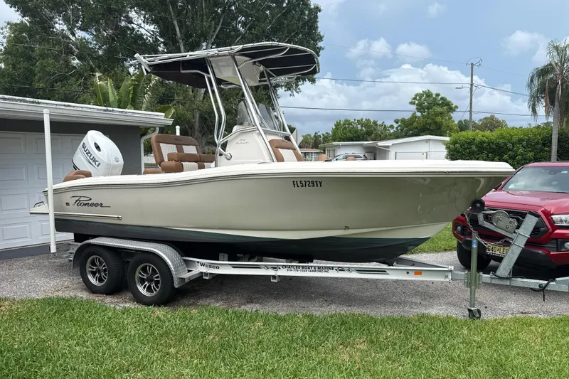 The Image of 2023 Pioneer 202 Islander boat on trailer, parked in residential driveway. - 0
