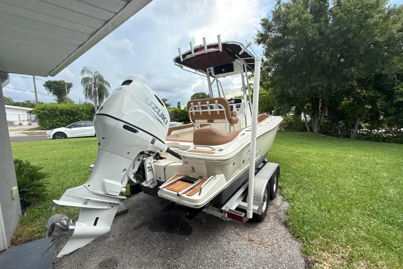 Slide: The Image of 2023 Pioneer 202 Islander boat with Suzuki outboard motor on trailer, parked in a driveway. - 16