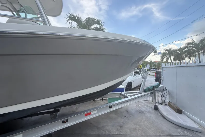 Slide: The Image of 2007 Robalo R260 Center Console boat on trailer, parked outdoors with palm trees. - 28