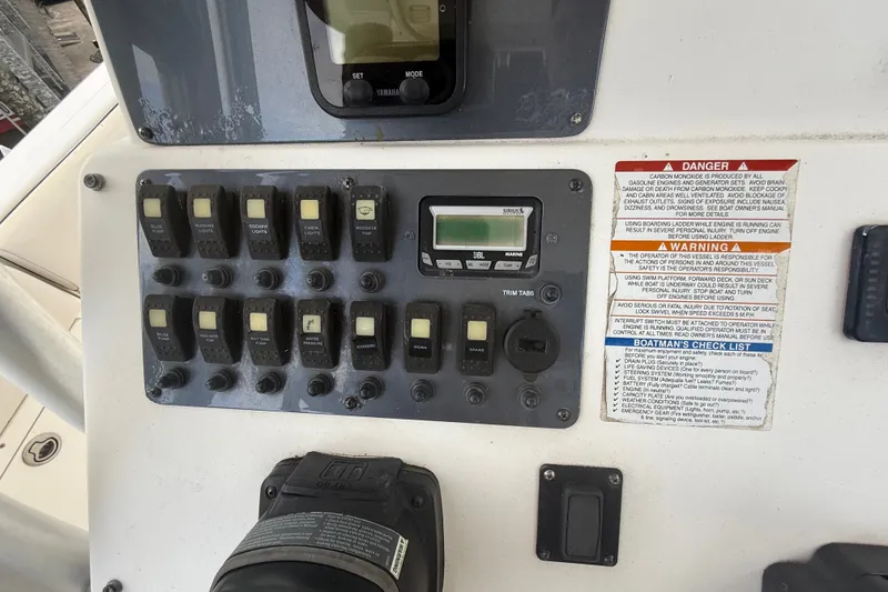 Slide: The Image of Control panel of a 2007 Robalo R260 Center Console boat with switches and warnings. - 51