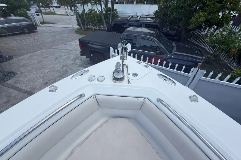 Slide: The Image of 2007 Robalo R260 Center Console boat bow with seating, parked near black trucks. - 38