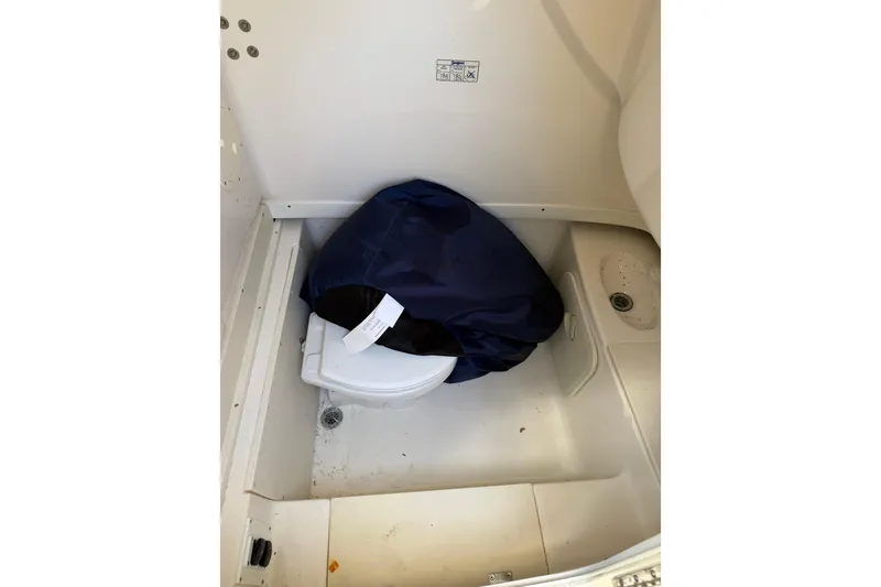 Slide: The Image of 2007 Robalo R260 Center Console boat interior with covered toilet and drain. - 7