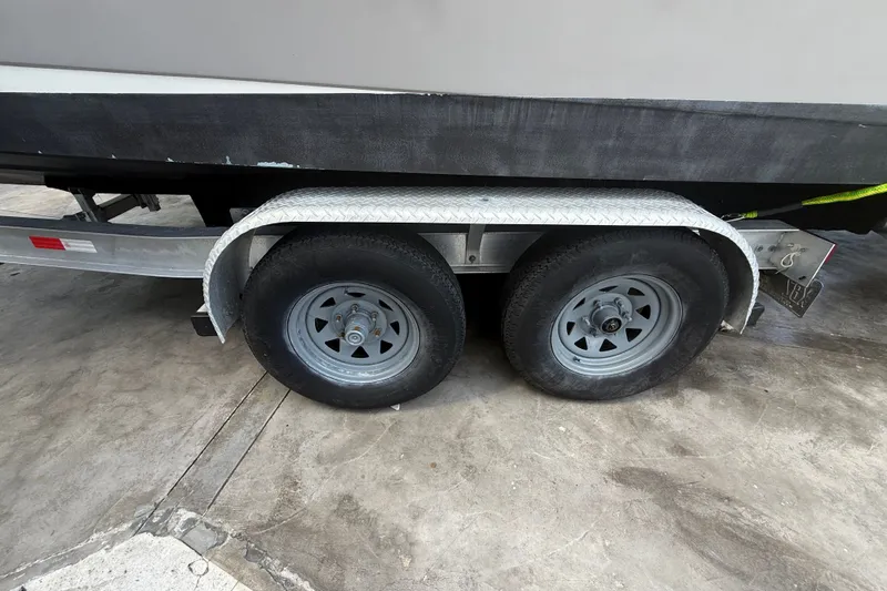 Slide: The Image of Trailer wheels of a 2007 Robalo R260 Center Console boat on concrete surface. - 8