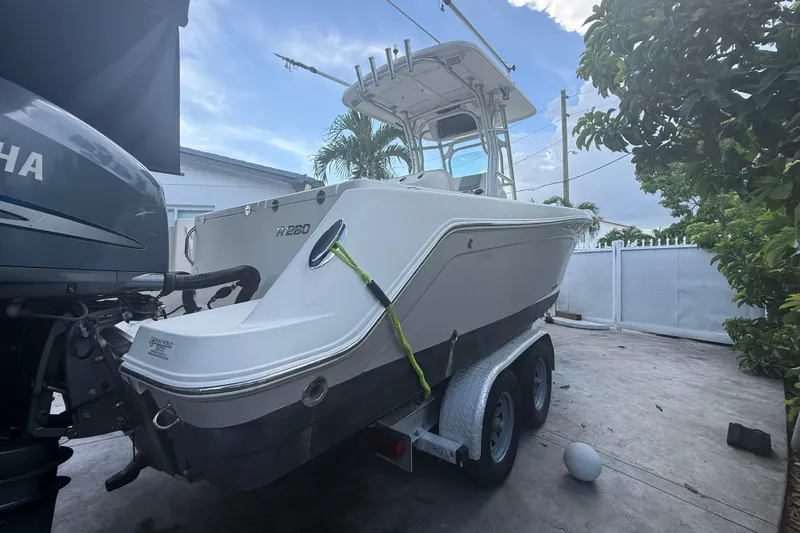 Slide: The Image of 2007 Robalo R260 Center Console boat on trailer, parked outdoors near a Yamaha engine. - 25