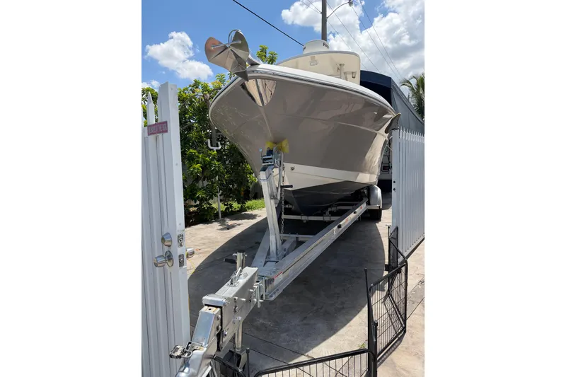 Slide: The Image of 2007 Robalo R260 Center Console boat on trailer, parked in driveway under blue sky. - 3