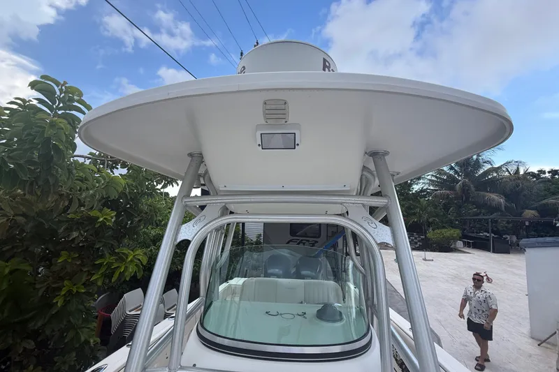 Slide: The Image of 2007 Robalo R260 Center Console boat with T-top, surrounded by tropical greenery. - 32