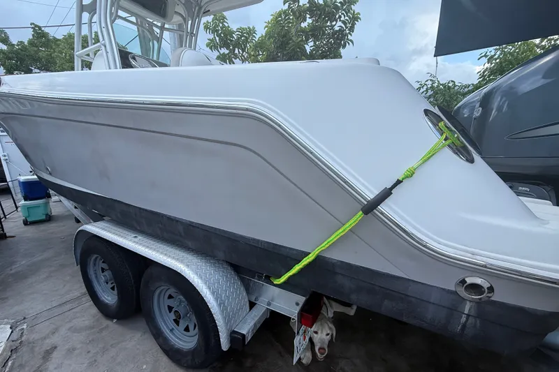 Slide: The Image of 2007 Robalo R260 Center Console boat on trailer, secured with green rope. - 7